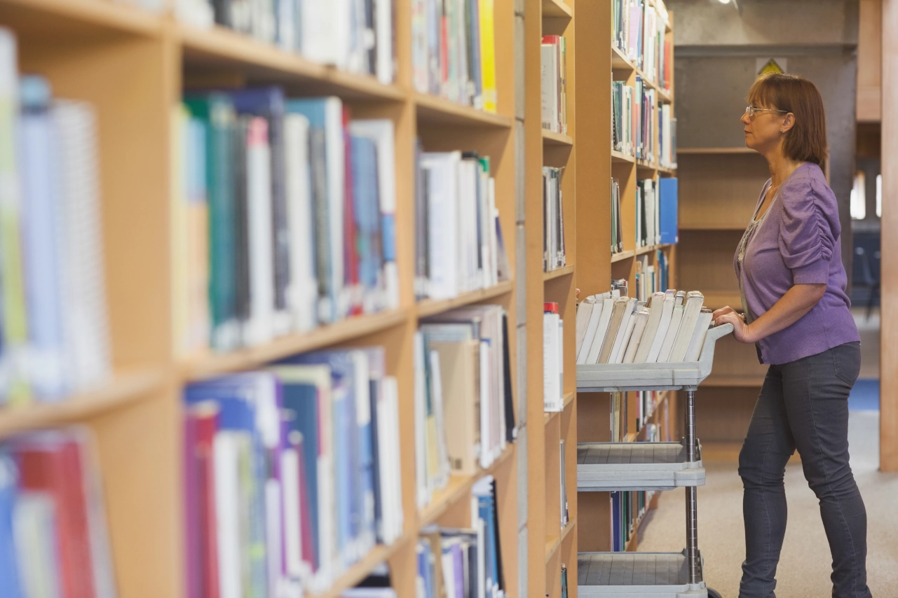 bibliotekarka z wózkiem z książkami